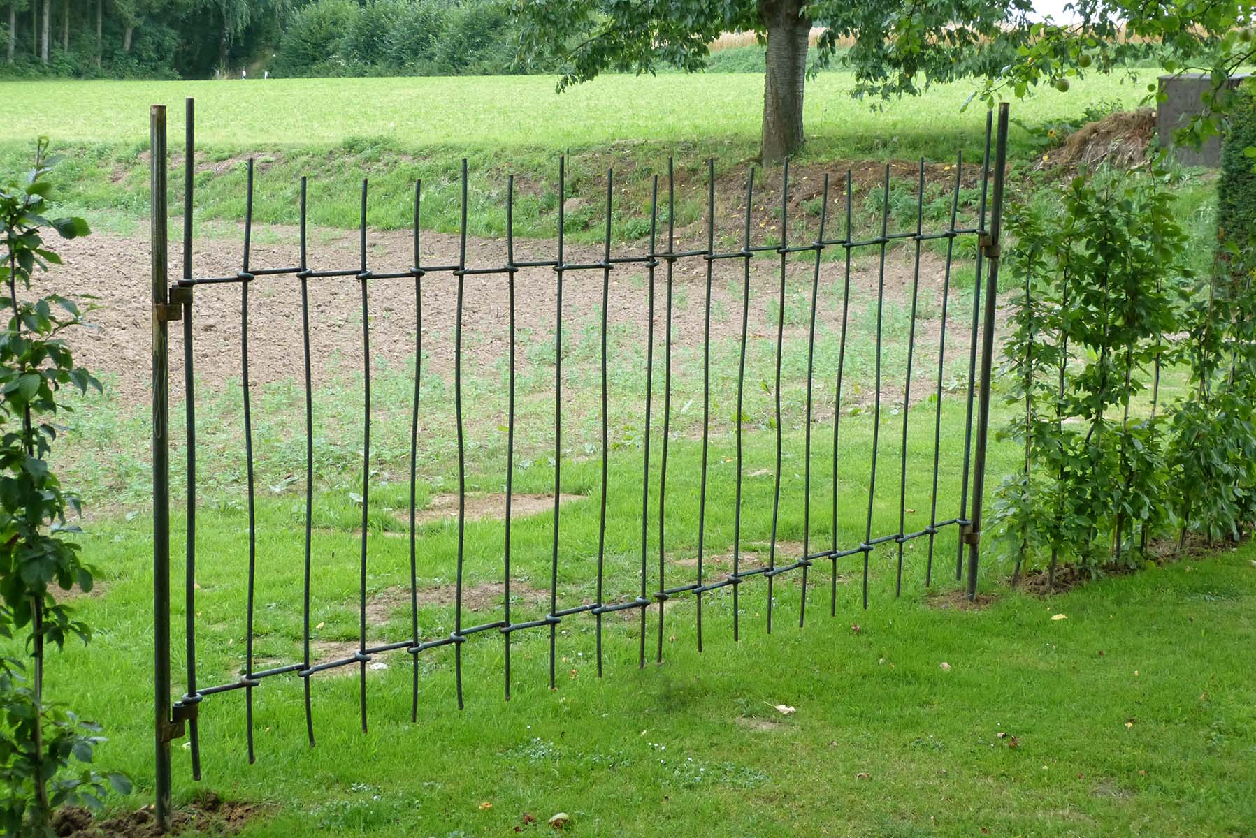 Zaun aus handgeschmiedeten Rohstahlstäben